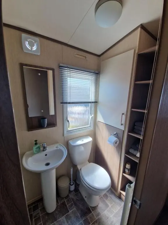 a small bathroom with a toilet and a sink at Cladach in Lossiemouth