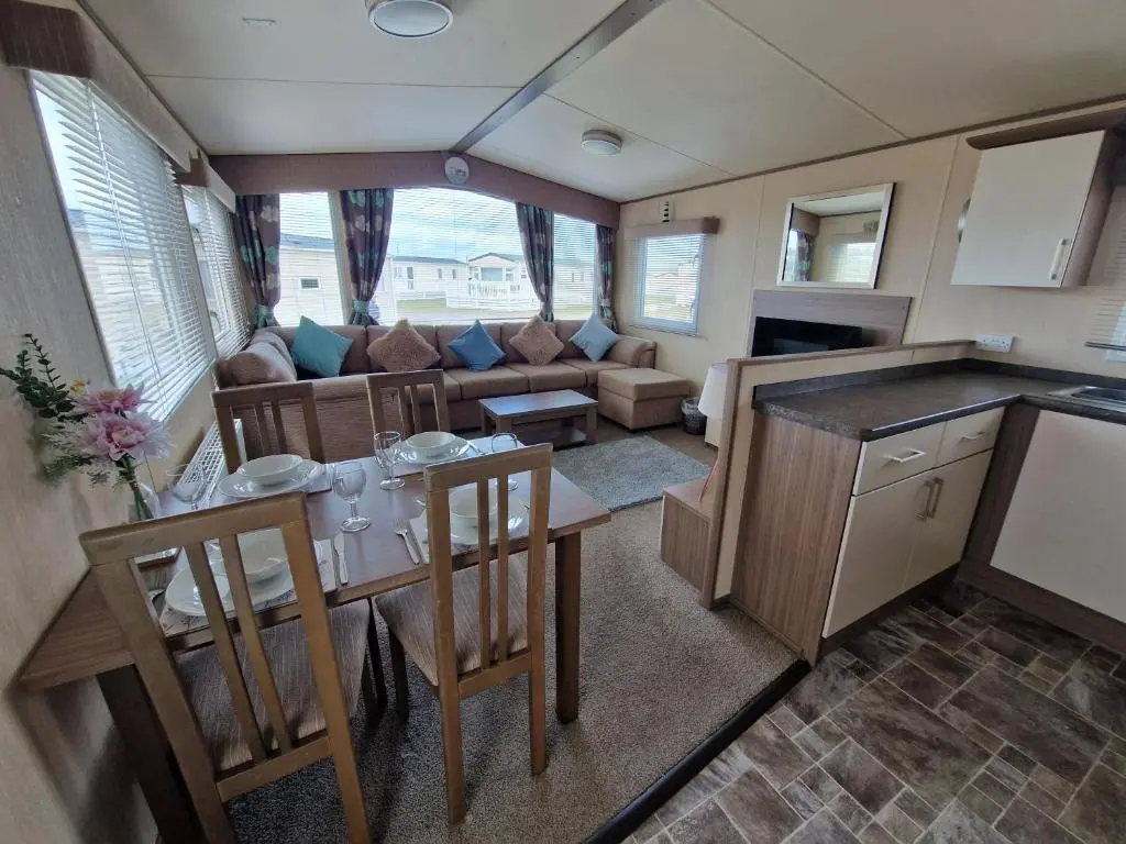a kitchen and living room with a table and chairs at Cladach in Lossiemouth