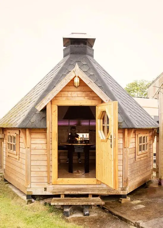 a large wooden building with a table in it at The Loft Glamping & Camping in Kinloss