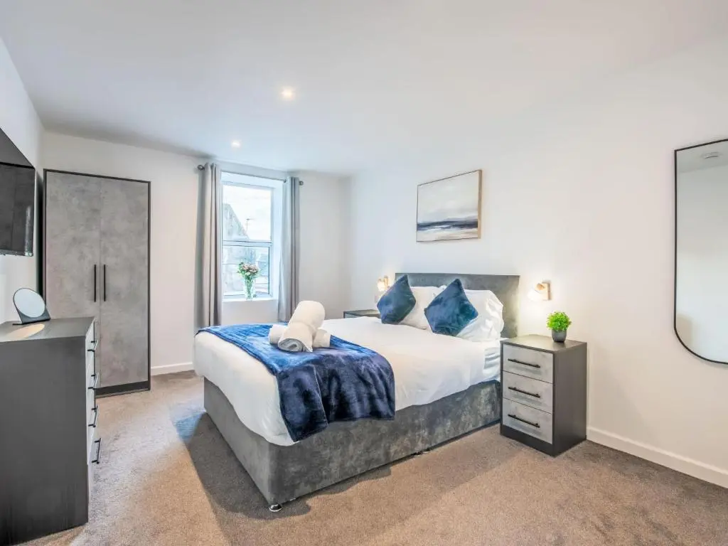a bedroom with a large bed and a tv at Apartment Fishertown Apartment 1st Floor by Interhome in Nairn