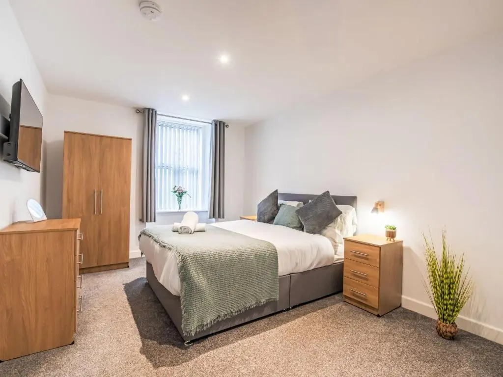 a bedroom with a large bed and a television at Apartment Fishertown Apartment by Interhome in Nairn
