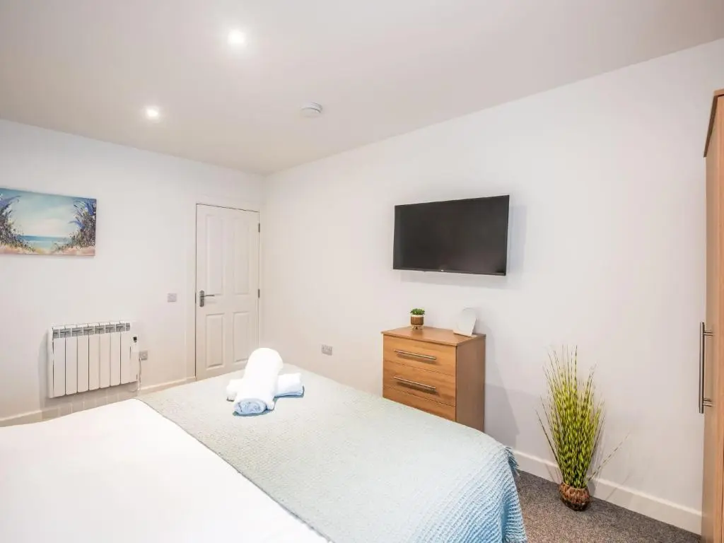 a bedroom with a bed and a tv on the wall at Apartment Fishertown Apartment by Interhome in Nairn