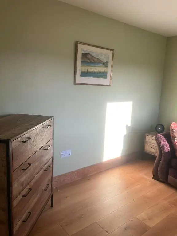a living room with a wooden dresser and a window at Dalvourn West Wing , Farr by Inverness in Tordarroch