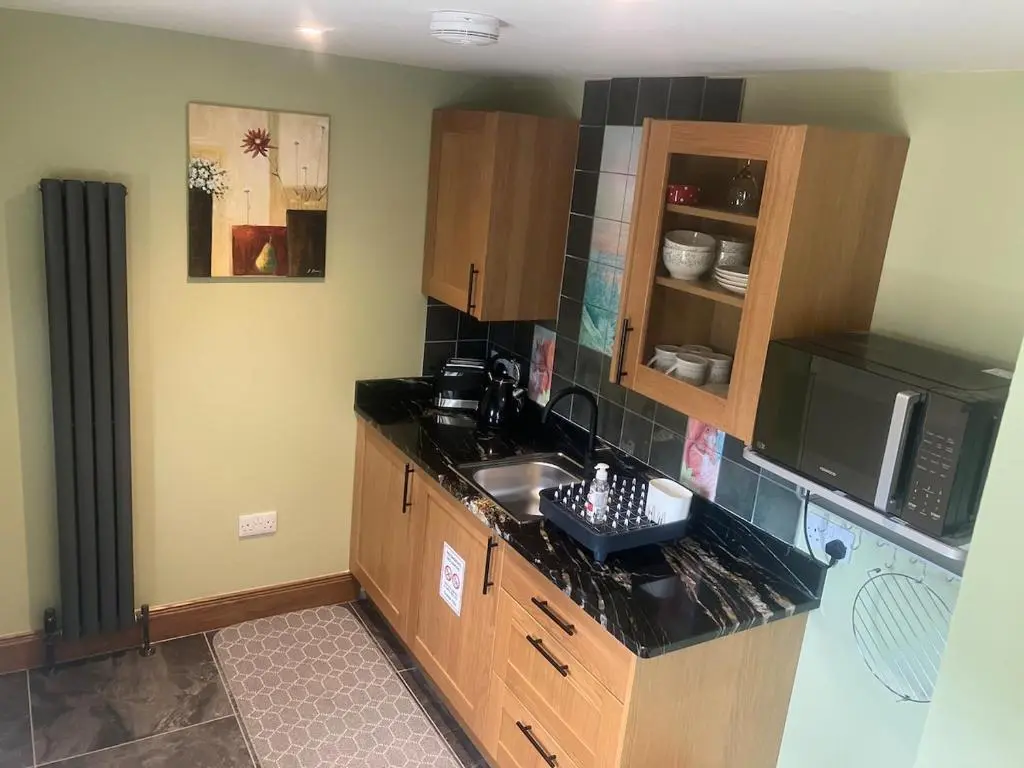 a kitchen with a sink and a microwave at Dalvourn West Wing , Farr by Inverness in Tordarroch