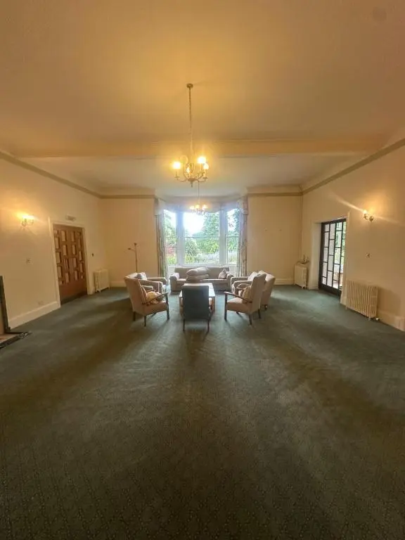 an empty living room with a couch and chairs at Cluny Hill Hotel in Forres
