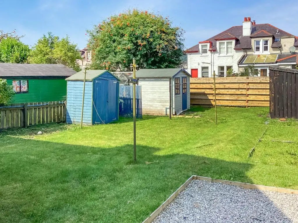 a yard with two sheds and a fence at Amayrah Cottage in Inverness