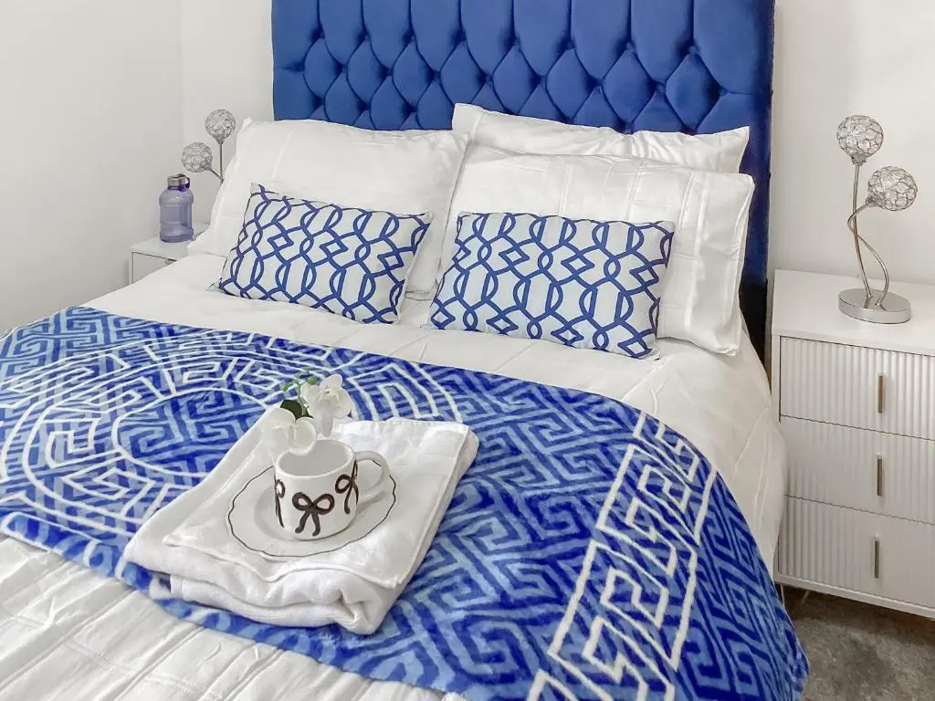 a blue and white bed with a tray with a cake on it at Amayrah Cottage in Inverness
