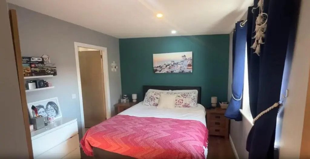 a bedroom with a bed and a green wall at White Crystal in Invergordon
