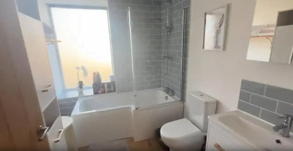 a bathroom with a tub and a toilet and a sink at White Crystal in Invergordon