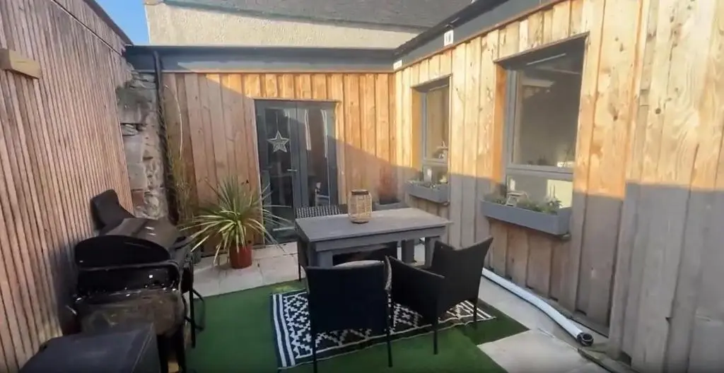 a patio with a table and chairs on a fence at White Crystal in Invergordon