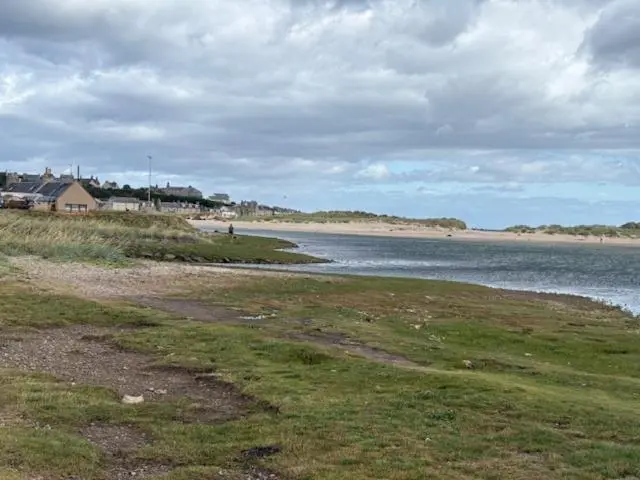 a beach with a body of water and a house at Summer breeze in Lossiemouth
