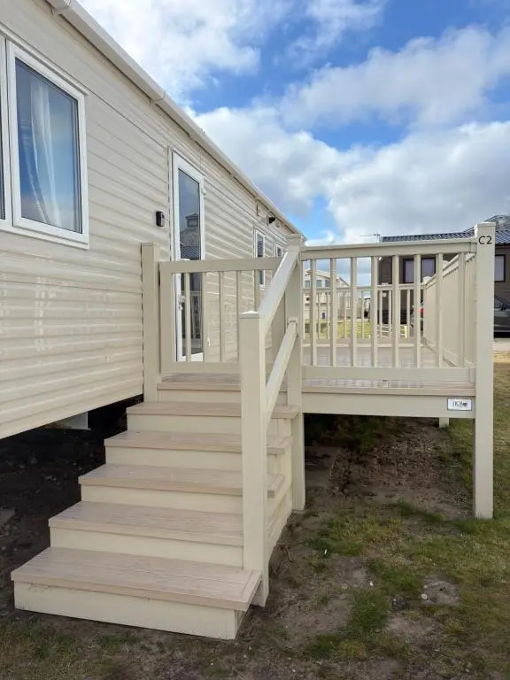 a staircase leading up to a manufactured home with a house at Summer breeze in Lossiemouth