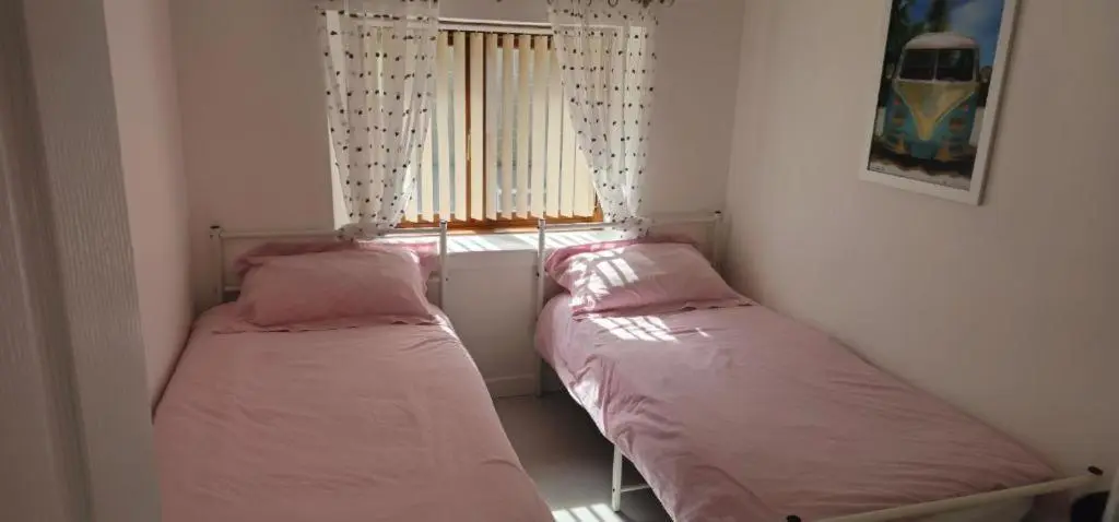 two beds in a small room with a window at Coastal Bliss, Rosehearty, Fraserburgh in Rosehearty