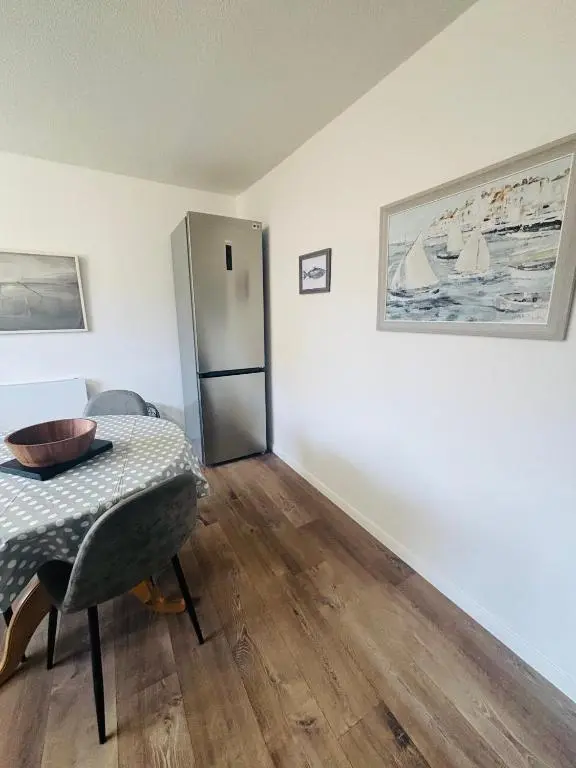 a dining room with a table and a refrigerator at Number Sixteen in Kildary