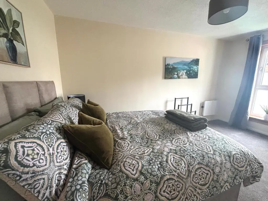 a bedroom with a bed and a couch at Number Sixteen in Kildary