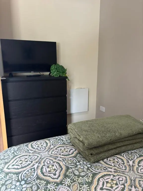 a bedroom with a bed with a flat screen tv at Number Sixteen in Kildary
