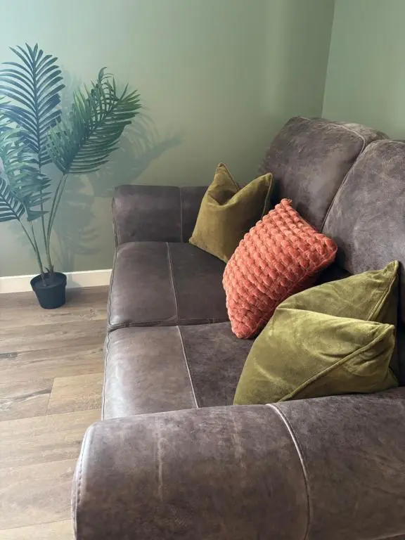 a brown couch with pillows on it in a living room at Number Sixteen in Kildary
