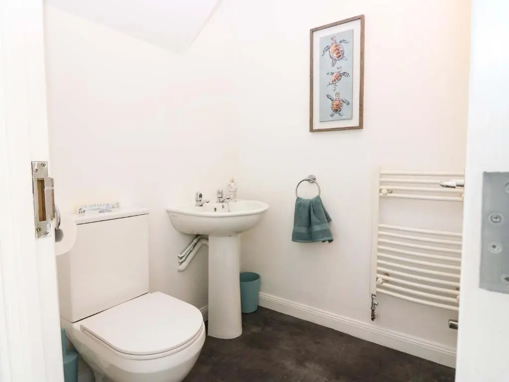 a white bathroom with a toilet and a sink at No 9 North St in Fraserburgh