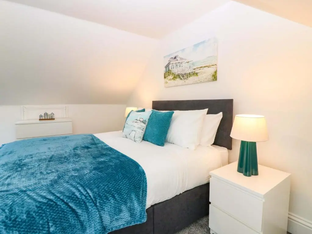 a bedroom with a bed with a blue blanket at No 9 North St in Fraserburgh