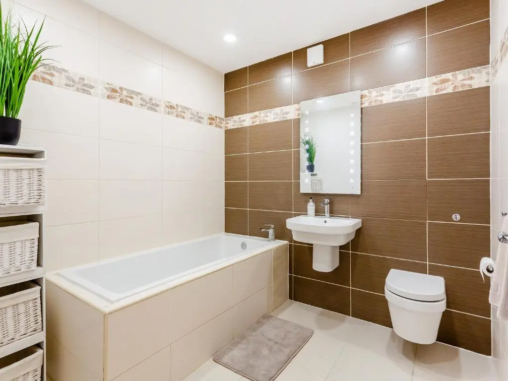 a bathroom with a tub and a toilet and a sink at Corrie Burn Villa in Ullapool