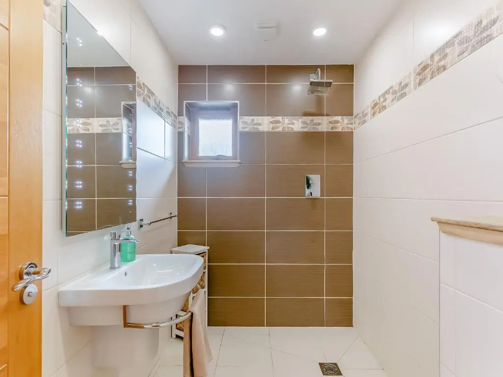 a bathroom with a sink and a mirror at Corrie Burn Villa in Ullapool