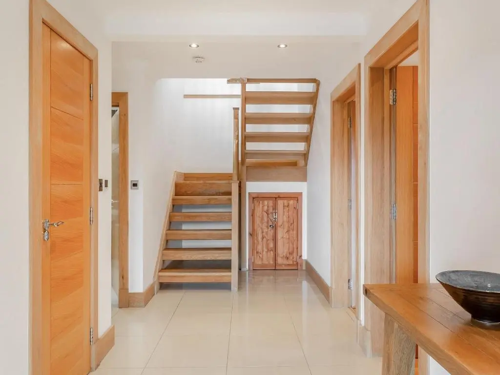 a hallway with wooden stairs in a house at Corrie Burn Villa in Ullapool
