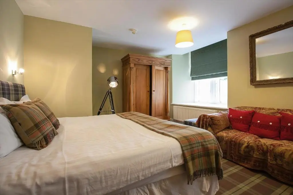 a bedroom with a bed and a couch at The Livingstone Loch Ness OS9 in Fort Augustus