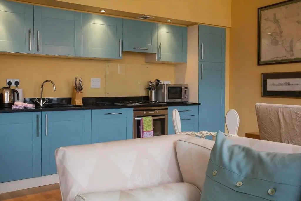 a living room with blue cabinets and a white couch at The Livingstone Loch Ness OS9 in Fort Augustus