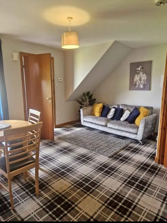 a living room with a couch and a table at Bright 2 Bed Corner Flat - Great Location in South Kessock