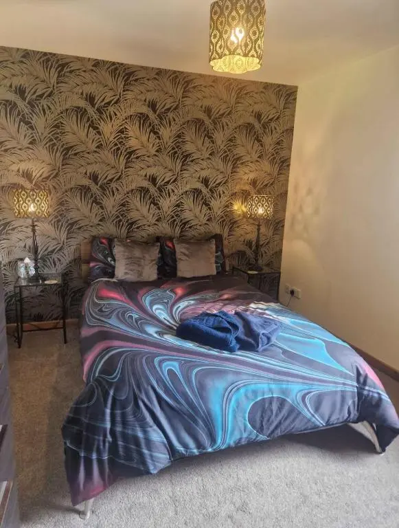 a bedroom with a bed with a colorful blanket at Bright 2 Bed Corner Flat - Great Location in South Kessock