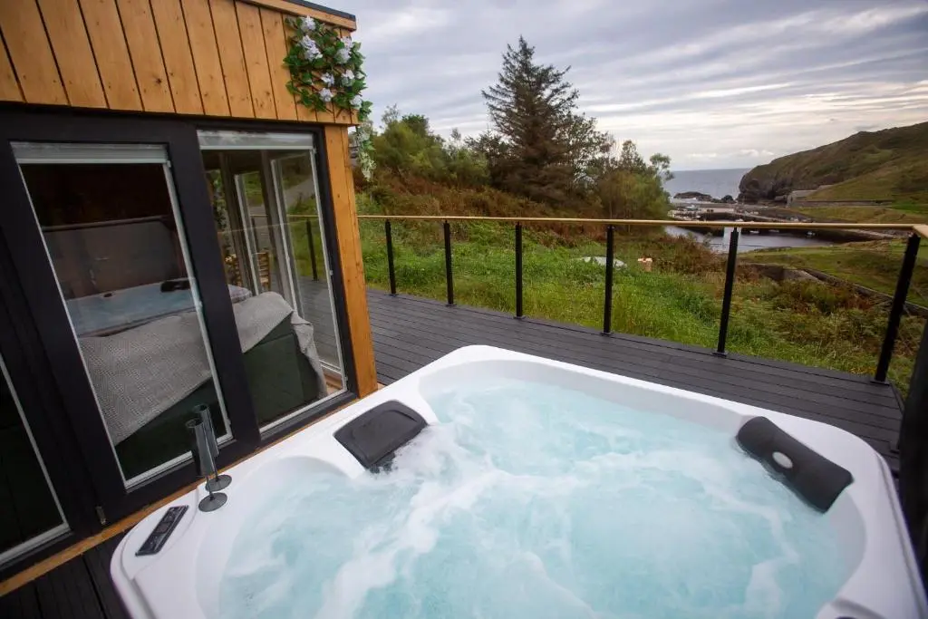 a bath tub on a deck with a view of the ocean at Fishers Rest in Lybster
