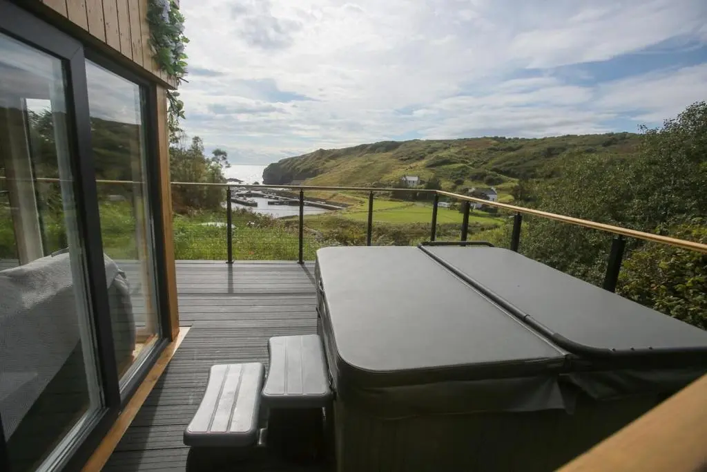 a balcony with a bench and a view of the ocean at Fishers Rest in Lybster
