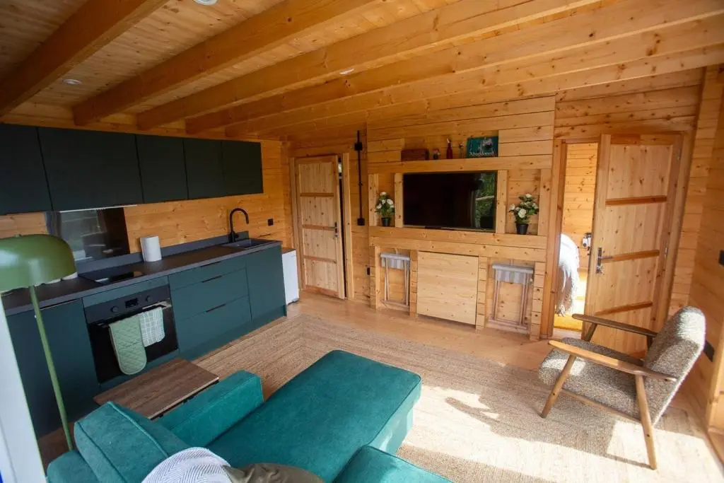 a living room with a blue couch in a cabin at Fishers Rest in Lybster