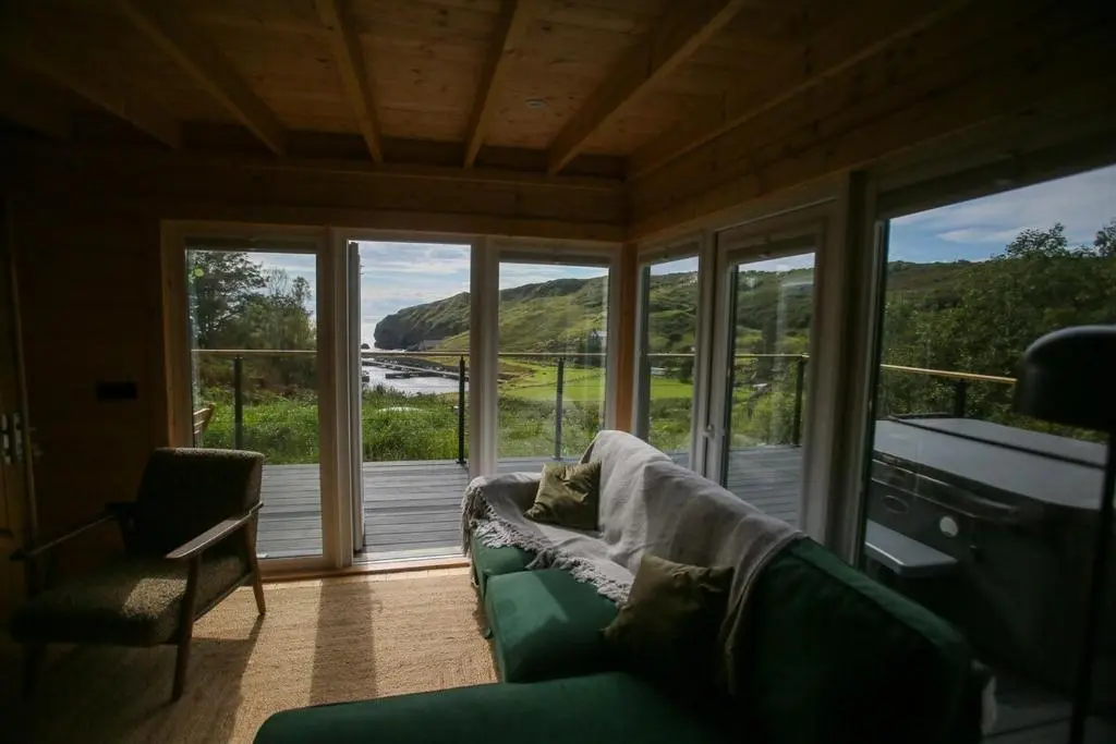 a living room with a couch and a large window at Fishers Rest in Lybster