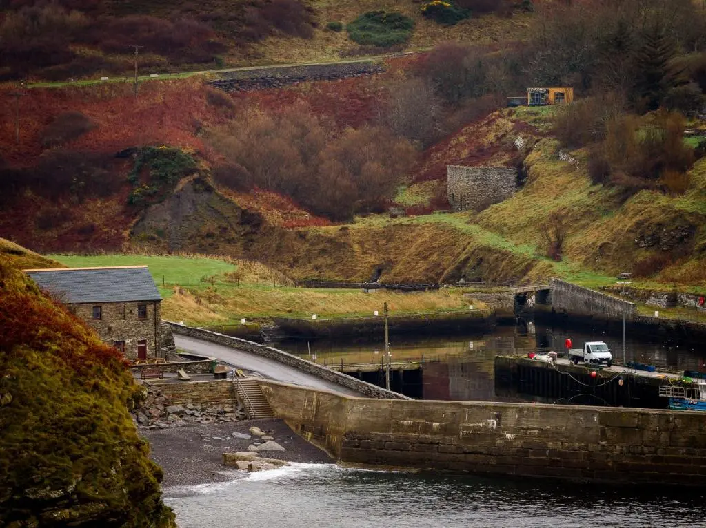 a bridge over a body of water next to a mountain at Fishers Rest in Lybster