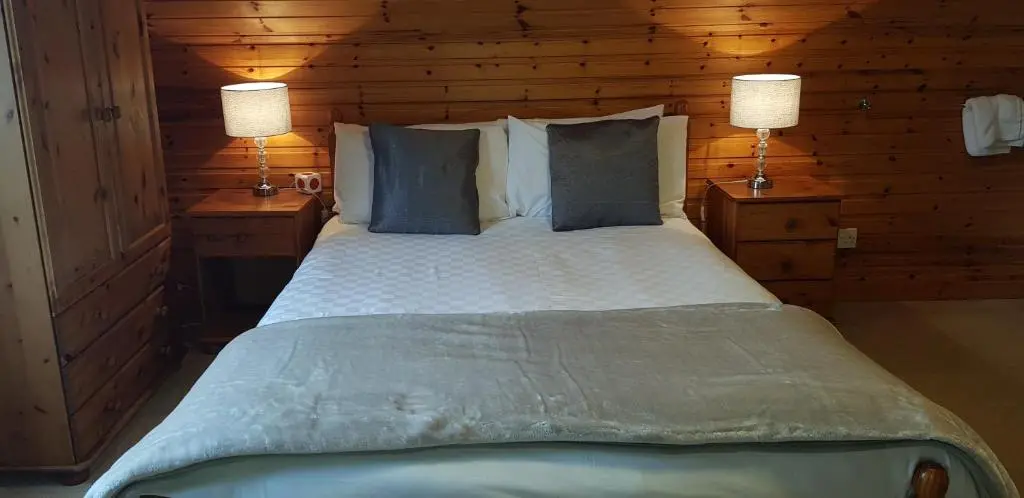 a bedroom with a large bed with two lamps at Carn Mhor Bed and Breakfast in Aviemore
