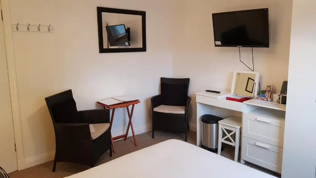 a room with two chairs and a desk with a television at Carn Mhor Bed and Breakfast in Aviemore