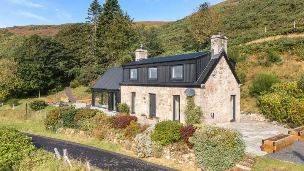 an aerial view of a stone house with a black roof at The Top House, Lothmore in Helmsdale