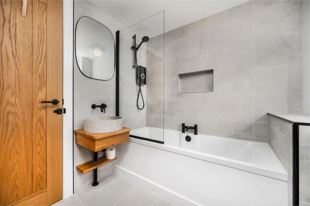 a bathroom with a tub and a sink and a mirror at The Top House, Lothmore in Helmsdale