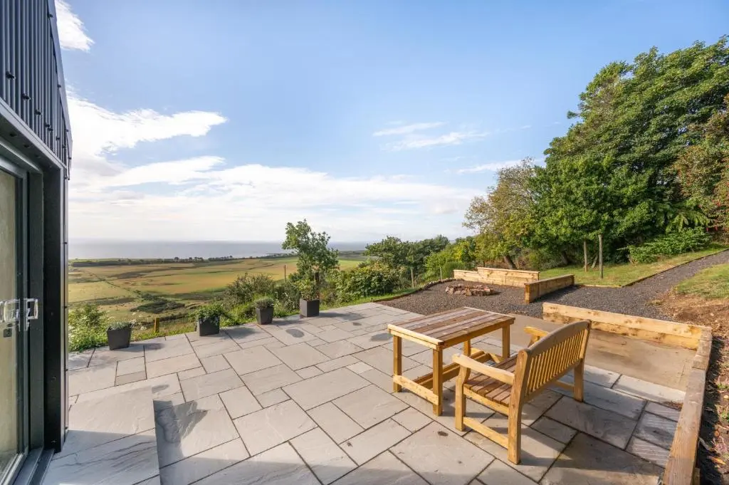 a patio with a table and a bench on it at The Top House, Lothmore in Helmsdale