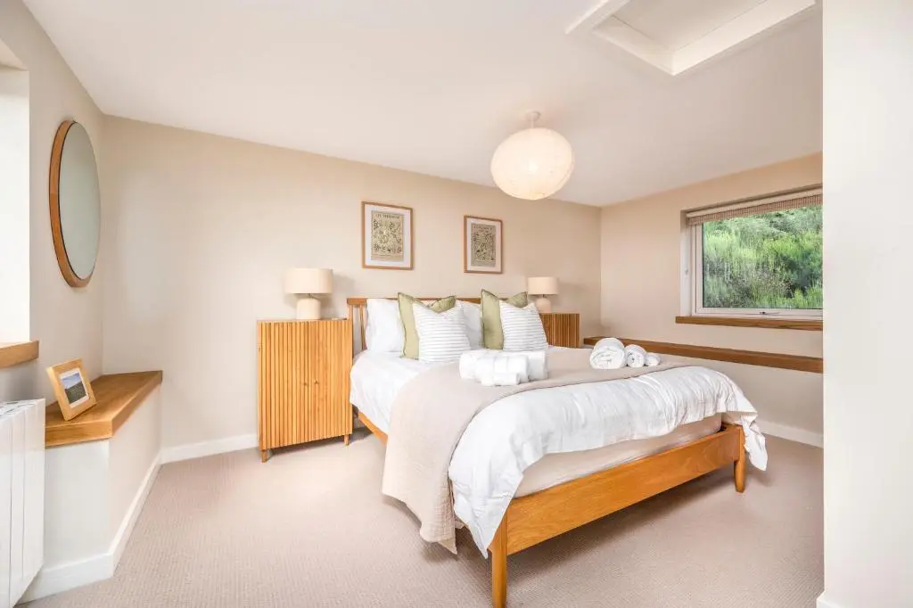 a bedroom with two beds and a window at The Top House, Lothmore in Helmsdale