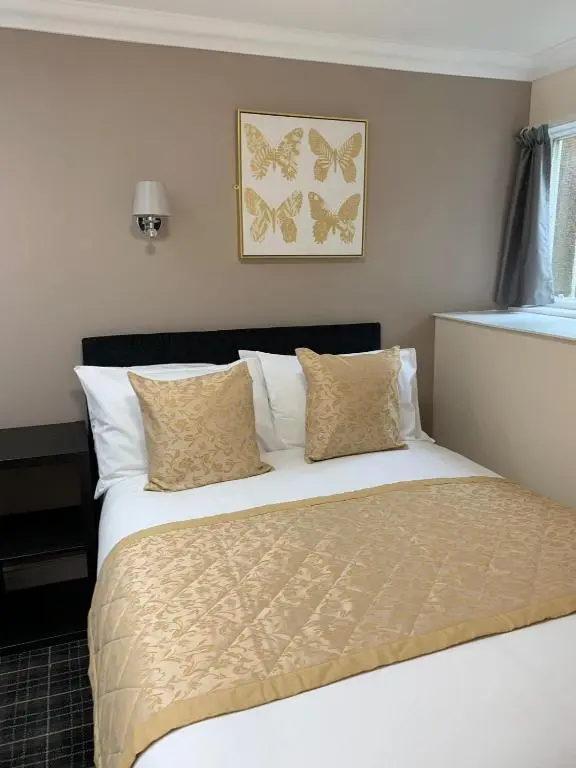 a bedroom with a bed with white sheets and butterflies on the wall at Royal Hotel in Dingwall