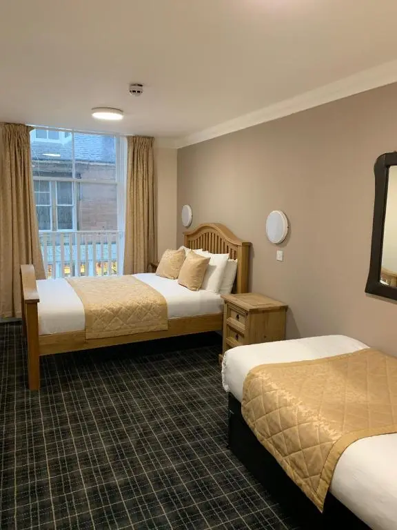 a hotel room with two beds and a window at Royal Hotel in Dingwall