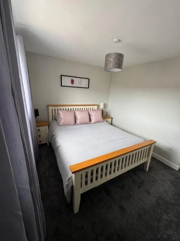 a bedroom with a bed with two pink pillows at Inward Oasis Relax and unwind in Buckie