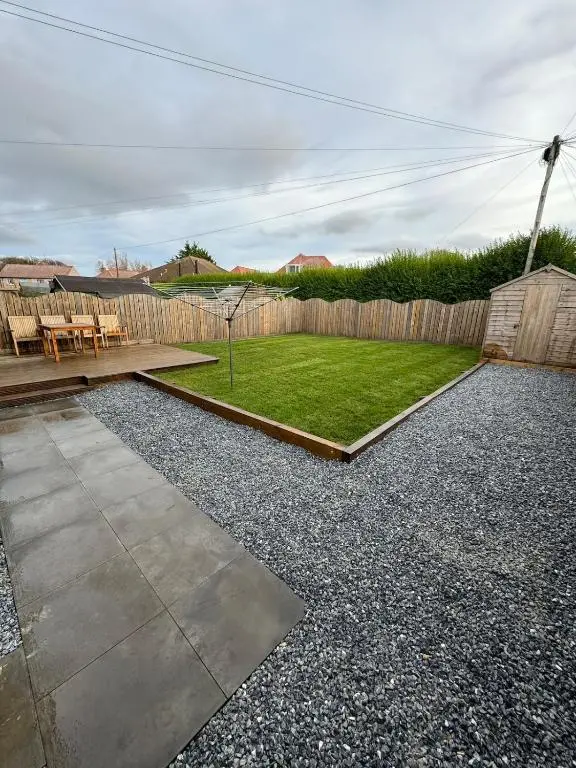 a backyard with a wooden fence and a lawn at Inward Oasis Relax and unwind in Buckie