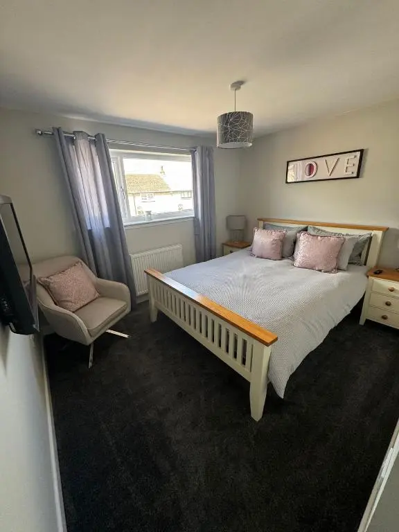 a bedroom with a large bed and a chair at Inward Oasis Relax and unwind in Buckie