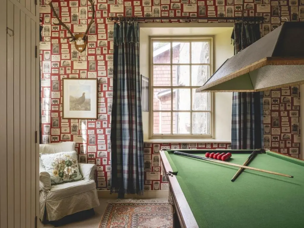 a living room with a pool table in front of a wall at Lairg Lodge in Lairg