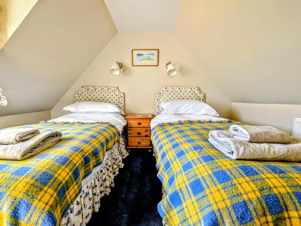 two twin beds in a attic bedroom at Reids Cottage in Lairg