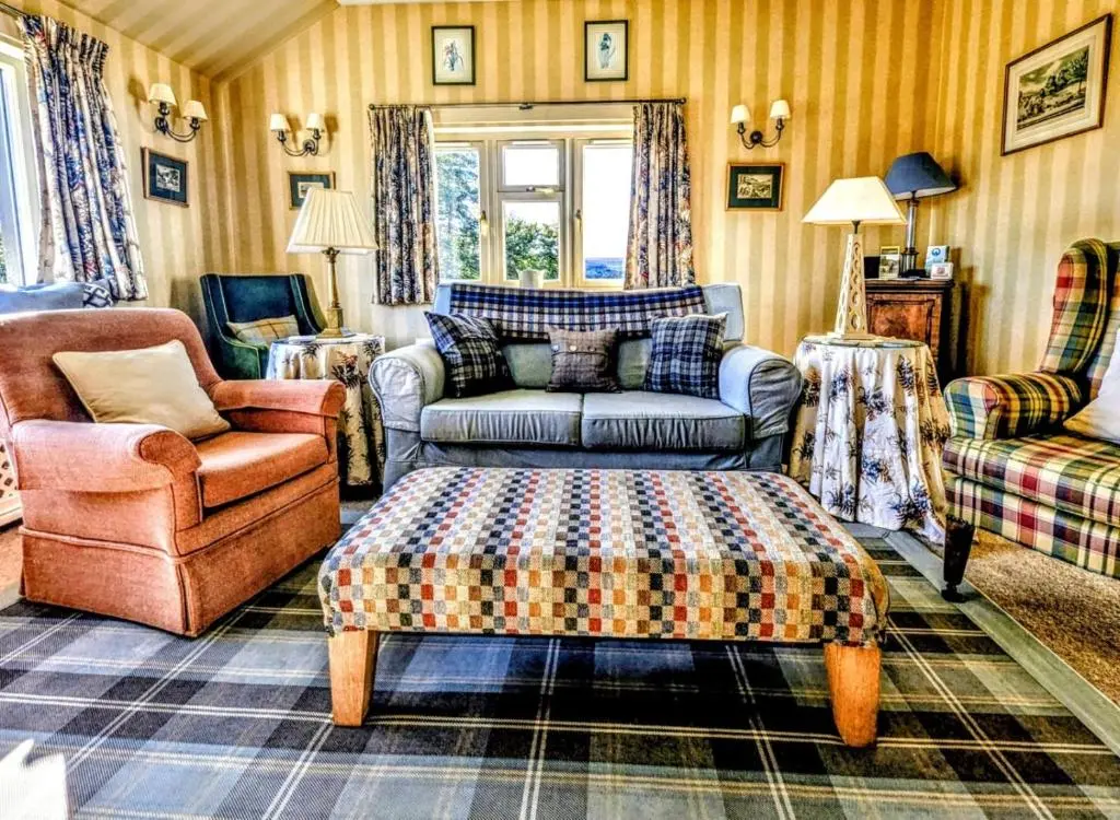 a living room with a couch and a chair at Reids Cottage in Lairg
