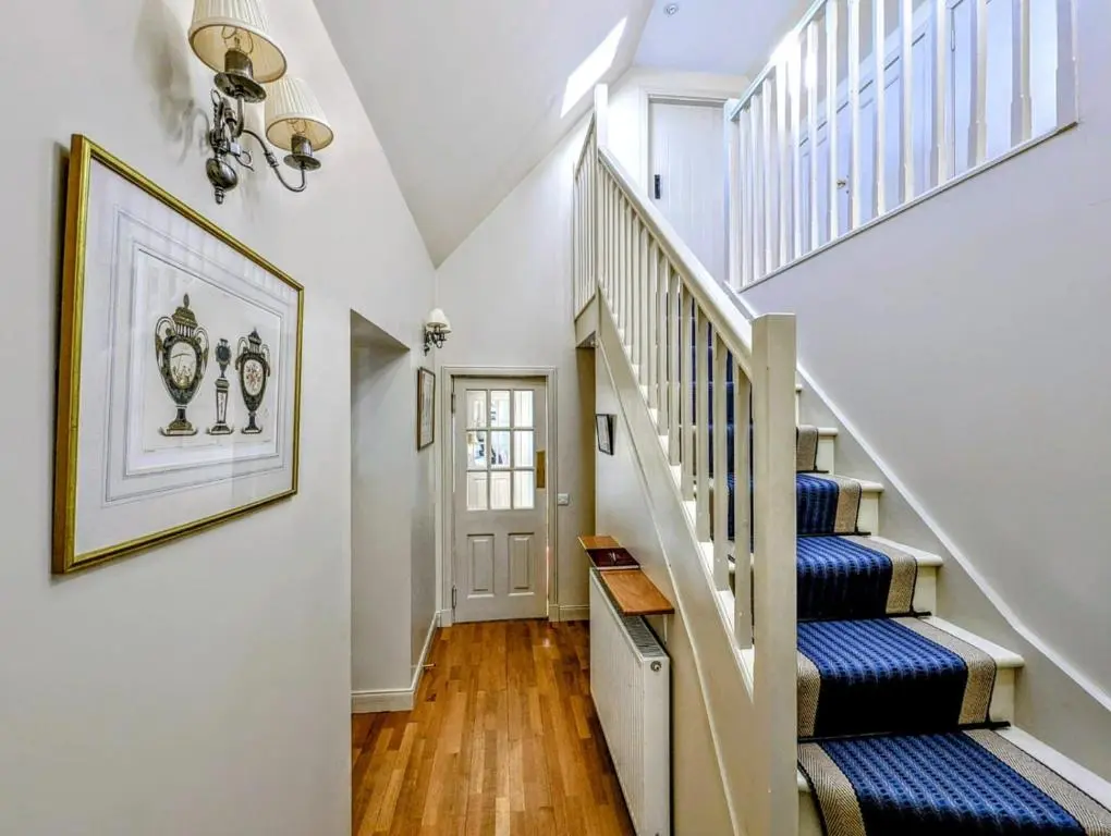 a staircase in a home with blue and white walls at Reids Cottage in Lairg
